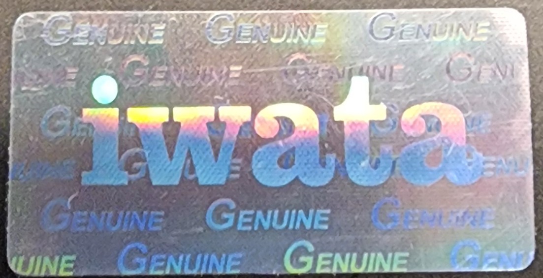 Closeup of counterfeit iwata hologram with no swoosh above logo